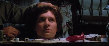 Movie still from “The Last Starfighter” (1984), directed by Nick Castle – A young man with brown hair looking into a mirror; Close Up shot, Over the shoulder angle