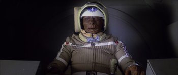 Movie still from “The Last Starfighter” (1984), directed by Nick Castle – An old man in a space suit with a helmet on his head; Close Up shot, Overhead angle