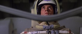 Movie still from “The Last Starfighter” (1984), directed by Nick Castle – A man in a space suit and helmet looking up; Close Up shot, Overhead angle