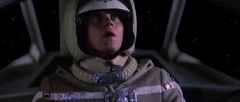 Movie still from “The Last Starfighter” (1984), directed by Nick Castle – A man in a space suit looking up at the sky; Close Up shot, Low angle