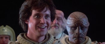 Movie still from “The Last Starfighter” (1984), directed by Nick Castle – A group of people standing next to each other; Close Up shot, Over the shoulder angle