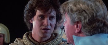 Movie still from “The Last Starfighter” (1984), directed by Nick Castle – A man in a costume talking to another man in a costume; Close Up shot, Over the shoulder angle
