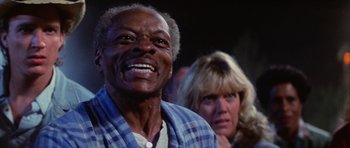 Movie still from “The Last Starfighter” (1984), directed by Nick Castle – An older man and a younger woman are smiling; Close Up shot, Low angle