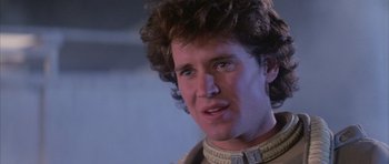 Movie still from “The Last Starfighter” (1984), directed by Nick Castle – A person wearing a suit; Close Up shot, Low angle