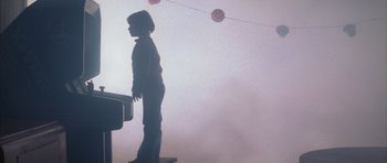 Movie still from “The Last Starfighter” (1984), directed by Nick Castle – A child standing in a room in the fog; Wide shot, Low angle