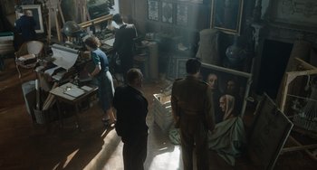 Movie still from “The Last Vermeer” (2019), directed by Dan Friedkin – A group of people standing around in a room; Wide shot, High angle