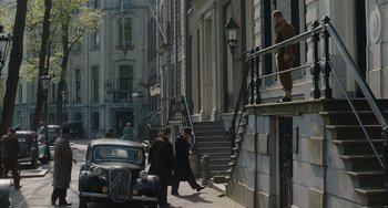 Movie still from “The Last Vermeer” (2019), directed by Dan Friedkin – A group of people walking down a street; Extreme Wide shot, Low angle