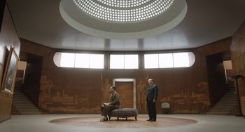 Movie still from “The Last Vermeer” (2019), directed by Dan Friedkin – Two men are standing in a large room; Extreme Wide shot, Low angle