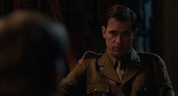 Movie still from “The Last Vermeer” (2019), directed by Dan Friedkin – A person wearing a military uniform; Close Up shot, Over the shoulder angle