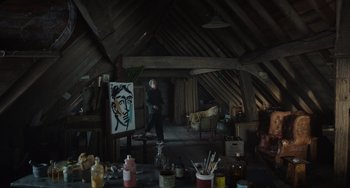 Movie still from “The Last Vermeer” (2019), directed by Dan Friedkin – A man standing in front of an easel in an attic; Wide shot, Low angle