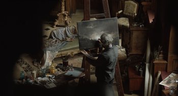 Movie still from “The Last Vermeer” (2019), directed by Dan Friedkin – An older man is painting in a room; Wide shot, High angle