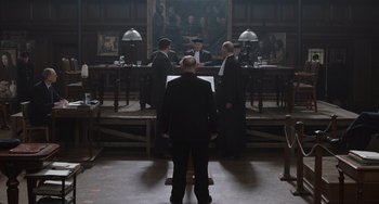 Movie still from “The Last Vermeer” (2019), directed by Dan Friedkin – A group of men in suits standing in front of a courtroom; Wide shot, High angle