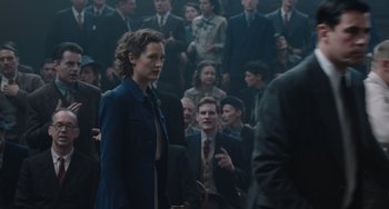 Movie still from “The Last Vermeer” (2019), directed by Dan Friedkin – A group of people standing in front of a group of men; Medium shot, Over the shoulder angle