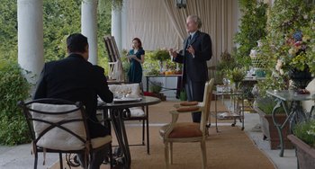 Movie still from “The Last Vermeer” (2019), directed by Dan Friedkin – A man in a suit and tie standing in front of two other people; Wide shot, Over the shoulder angle