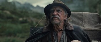 Movie still from “The Last Voyage of the Demeter” (2023), directed by André Øvredal – An old man with a beard wearing a hat; Close Up shot, Low angle