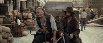 Movie still from “The Last Voyage of the Demeter” (2023), directed by André Øvredal – Two men sitting next to each other in front of an old car; Medium shot, Over the shoulder angle