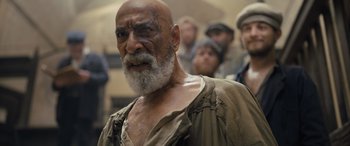 Movie still from “The Last Voyage of the Demeter” (2023), directed by André Øvredal – An old man with a beard is looking at the camera; Close Up shot, Over the shoulder angle