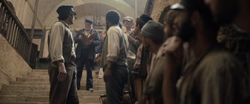 Movie still from “The Last Voyage of the Demeter” (2023), directed by André Øvredal – A group of men standing on some stairs; Wide shot, Over the shoulder angle