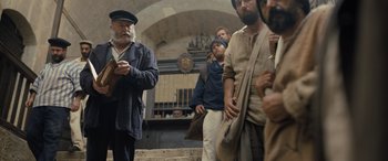 Movie still from “The Last Voyage of the Demeter” (2023), directed by André Øvredal – A group of men standing next to each other in a building; Medium shot, Low angle