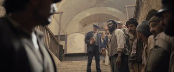 Movie still from “The Last Voyage of the Demeter” (2023), directed by André Øvredal – A group of people standing on some stairs; Wide shot, Low angle