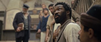 Movie still from “The Last Voyage of the Demeter” (2023), directed by André Øvredal – A group of men standing around a building; Close Up shot, Over the shoulder angle