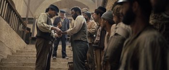 Movie still from “The Last Voyage of the Demeter” (2023), directed by André Øvredal – A group of men standing on some stairs; Medium shot, Over the shoulder angle