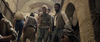 Movie still from “The Last Voyage of the Demeter” (2023), directed by André Øvredal – A group of men walking down a street; Wide shot, Over the shoulder angle