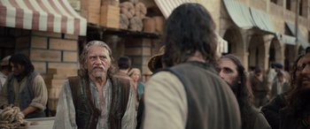 Movie still from “The Last Voyage of the Demeter” (2023), directed by André Øvredal – A man with long hair and a beard standing next to another man with long hair and a beard standing next to another man with long hair; Medium shot, Over the shoulder angle