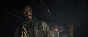 Movie still from “The Last Voyage of the Demeter” (2023), directed by André Øvredal – A man with a long beard standing in a dark room; Close Up shot, Over the shoulder angle