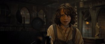 Movie still from “The Last Voyage of the Demeter” (2023), directed by André Øvredal – A young person with long brown hair in a room; Close Up shot, Low angle