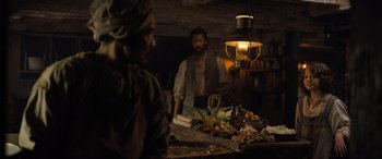 Movie still from “The Last Voyage of the Demeter” (2023), directed by André Øvredal – Two people in a room with a lantern hanging from the ceiling; Medium shot, Over the shoulder angle