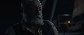 Movie still from “The Last Voyage of the Demeter” (2023), directed by André Øvredal – An old man with a beard and a mustache; Close Up shot, Over the shoulder angle