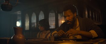 Movie still from “The Last Voyage of the Demeter” (2023), directed by André Øvredal – A man sitting at a table with a cup of coffee; Close Up shot, Low angle