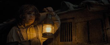Movie still from “The Last Voyage of the Demeter” (2023), directed by André Øvredal – A person holding a lantern in a dark room; Medium shot, Low angle
