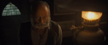 Movie still from “The Last Voyage of the Demeter” (2023), directed by André Øvredal – An old man with a beard is looking at the camera; Close Up shot, Low angle