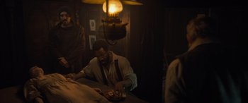 Movie still from “The Last Voyage of the Demeter” (2023), directed by André Øvredal – A man sitting at a table with a bowl of food; Medium shot, Over the shoulder angle