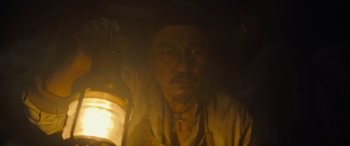 Movie still from “The Last Voyage of the Demeter” (2023), directed by André Øvredal – A man holding a lantern in a dark room; Close Up shot, Low angle
