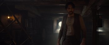 Movie still from “The Last Voyage of the Demeter” (2023), directed by André Øvredal – A man standing in a dark room with his hands in his pockets; Medium shot, Low angle