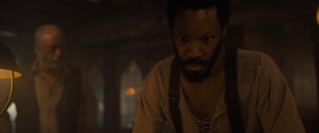 Movie still from “The Last Voyage of the Demeter” (2023), directed by André Øvredal – A man with a beard is looking at the camera; Close Up shot, High angle