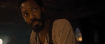 Movie still from “The Last Voyage of the Demeter” (2023), directed by André Øvredal – A person with a beard looking to his left; Close Up shot, High angle