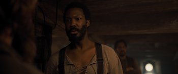 Movie still from “The Last Voyage of the Demeter” (2023), directed by André Øvredal – A man with a beard is standing next to another man; Close Up shot, Over the shoulder angle