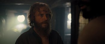Movie still from “The Last Voyage of the Demeter” (2023), directed by André Øvredal – A man with a long beard is looking at the camera; Close Up shot, Over the shoulder angle