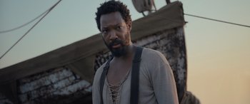Movie still from “The Last Voyage of the Demeter” (2023), directed by André Øvredal – A man with a beard wearing a sweater and suspenders; Close Up shot, Low angle