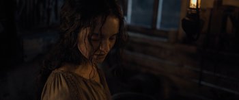 Movie still from “The Last Voyage of the Demeter” (2023), directed by André Øvredal – A woman with long dark curly hair looking down; Close Up shot, Over the shoulder angle