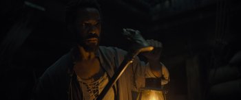 Movie still from “The Last Voyage of the Demeter” (2023), directed by André Øvredal – A man is holding a candle in the dark; Close Up shot, High angle