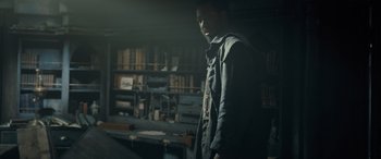 Movie still from “The Last Voyage of the Demeter” (2023), directed by André Øvredal – A man standing in a room filled with bookshelves; Medium shot, High angle