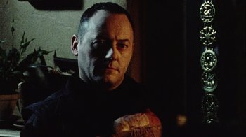 Movie still from “Dog Soldiers” (2002), directed by Neil Marshall – A person holding a piece of bread; Close Up shot, Low angle