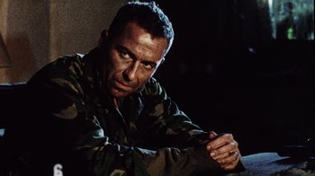 Movie still from “Dog Soldiers” (2002), directed by Neil Marshall – A man in a military uniform sitting in a dark room; Close Up shot, Low angle