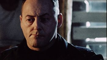 Movie still from “Dog Soldiers” (2002), directed by Neil Marshall – A person wearing a black shirt; Close Up shot, Low angle