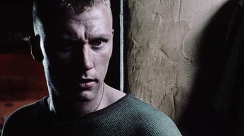 Movie still from “Dog Soldiers” (2002), directed by Neil Marshall – A person wearing a green shirt; Close Up shot, Low angle